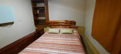 a small bedroom with a bed with a wooden headboard at La luisa segunda in Villa Parque Siquiman