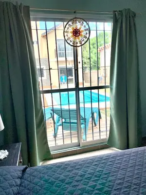 a bedroom with a window with a view of a pool at Depto Palmar in Villa Carlos Paz