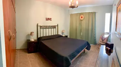 a bedroom with a bed and a table and a chair at Depto Palmar in Villa Carlos Paz