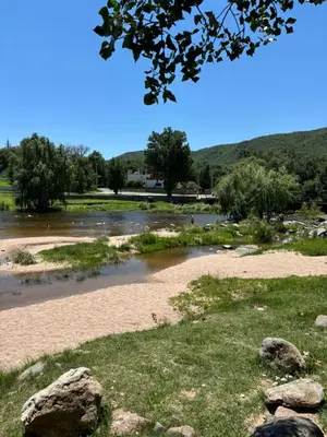 a view of a river with rocks in the foreground at Complejo playa de oro 1 in Villa Carlos Paz