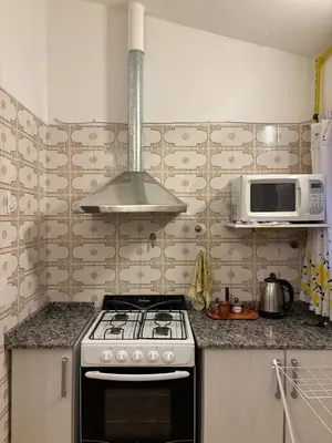 a kitchen with a stove and a microwave at Complejo playa de oro 1 in Villa Carlos Paz