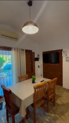 a dining room with a table and chairs and a television at Complejo playa de oro 1 in Villa Carlos Paz
