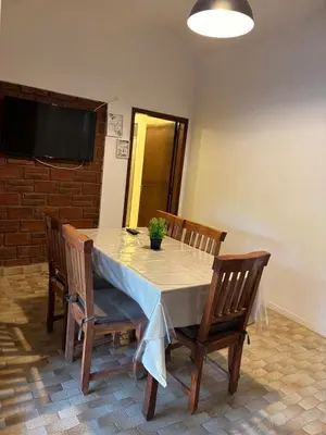 a dining room table with two chairs and a television at Complejo playa de oro 1 in Villa Carlos Paz