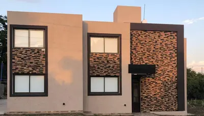 a brick building with four windows on it at Terra Bella Hidromasajes in San Antonio de Arredondo