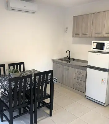 a kitchen with a white refrigerator and a table with chairs at Terra Bella Hidromasajes in San Antonio de Arredondo