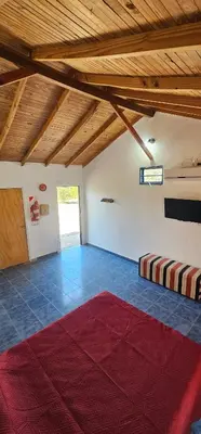 a large room with a red rug on the floor at Cabaña el fede in Carpintería