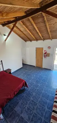 a room with a red bed and a wooden ceiling at Cabaña el fede in Carpintería