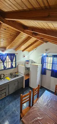 a kitchen with a refrigerator and a table and chairs at Cabaña el fede in Carpintería
