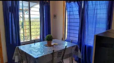 a table with a potted plant on it in front of windows at Mirador de las Sierras in Villa Parque Siquiman