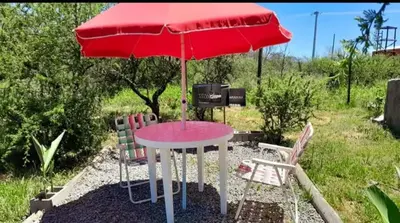 a table with a red umbrella and two chairs at Mirador de las Sierras in Villa Parque Siquiman
