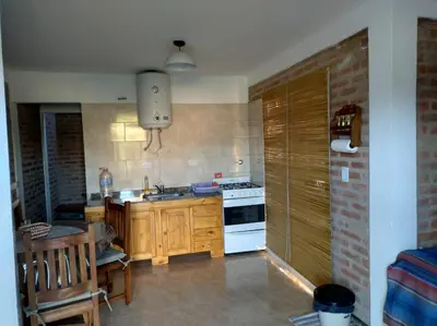 a kitchen with a sink and a stove top oven at Cabañas MANKU in San Lorenzo