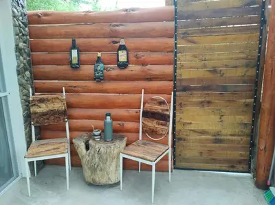 a wooden wall with two chairs and a table at Namaste Apart Cabaña in San Francisco del Monte de Oro