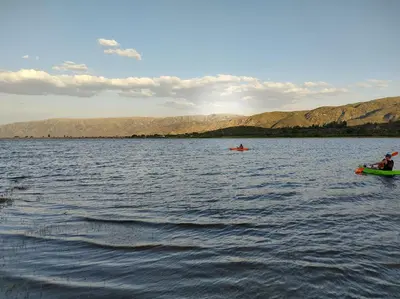 two people in boats on a large body of water at Namaste Apart Cabaña in San Francisco del Monte de Oro