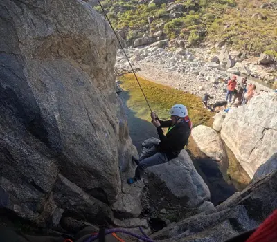 a person on a rope dangling from a rock formation at Namaste Apart Cabaña in San Francisco del Monte de Oro