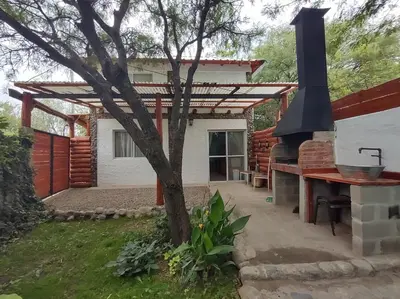 a backyard with a grill and a house at Namaste Apart Cabaña in San Francisco del Monte de Oro