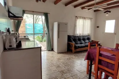a kitchen and living room with a refrigerator and a couch at Namaste Apart Cabaña in San Francisco del Monte de Oro