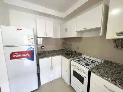 a kitchen with white cabinets and a white refrigerator at Apart San Jose a 200mts de la peatonal in Villa Carlos Paz