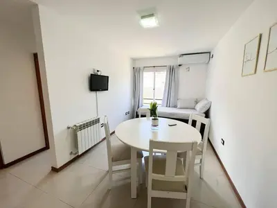 a white room with a table and a couch at Apart San Jose a 200mts de la peatonal in Villa Carlos Paz