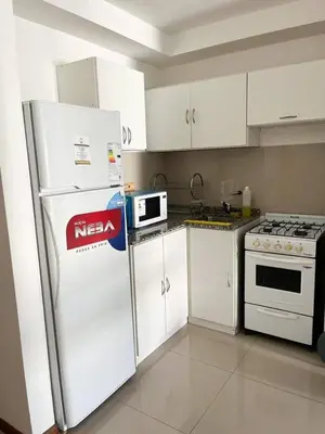 a kitchen with white cabinets and a white refrigerator at Apart San Jose a 200mts de la peatonal in Villa Carlos Paz