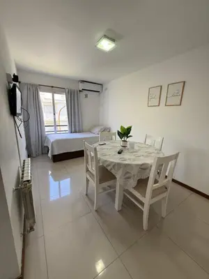 a dining room with a table and chairs and a bed at Apart San Jose a 200mts de la peatonal in Villa Carlos Paz