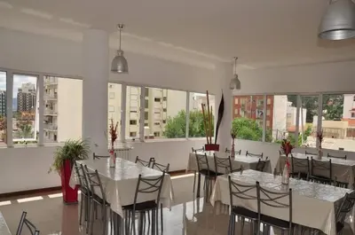 a dining room with tables and chairs and windows at Apart San Jose a 200mts de la peatonal in Villa Carlos Paz