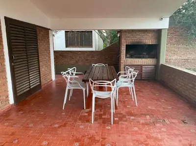 a wooden table and chairs on a brick patio at Complejo playa de oro 2 in Villa Carlos Paz