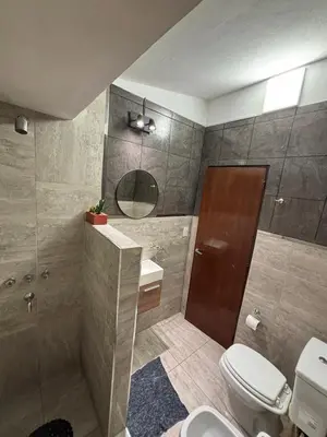 a bathroom with a toilet and a sink and a mirror at Complejo playa de oro 2 in Villa Carlos Paz