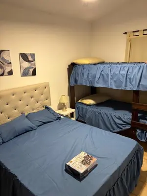 a bedroom with two bunk beds with a blue comforter at Complejo playa de oro 2 in Villa Carlos Paz