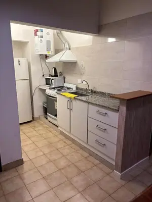 a kitchen with a sink and a stove and a refrigerator at Complejo playa de oro 2 in Villa Carlos Paz
