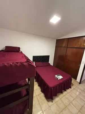 two beds in a room with red sheets at Complejo playa de oro 2 in Villa Carlos Paz
