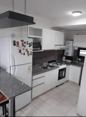 a kitchen with white cabinets and a white refrigerator at Dos Nogales 26 in Villa Carlos Paz
