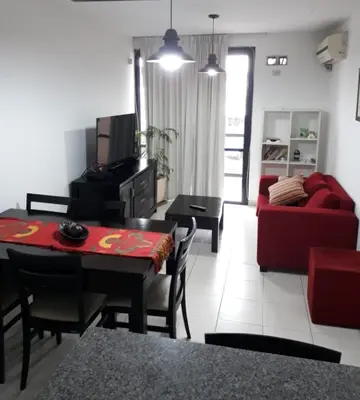 a living room with a red couch and a table at Dos Nogales 26 in Villa Carlos Paz