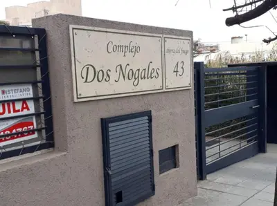 a sign on the side of a building with a door at Dos Nogales 26 in Villa Carlos Paz