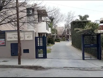 an empty street with a blue gate in front of a building at Dos Nogales 26 in Villa Carlos Paz