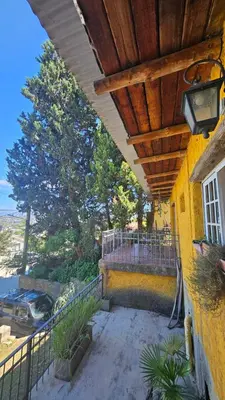 a house with a balcony with a wooden roof at Balcón de las sierras in Villa Carlos Paz
