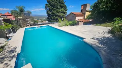 a blue swimming pool in a yard at Balcón de las sierras in Villa Carlos Paz