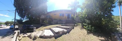 a building with a stone wall in front of a house at Balcón de las sierras in Villa Carlos Paz