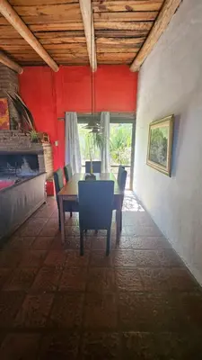 a dining room with red walls and a table and chairs at Balcón de las sierras in Villa Carlos Paz