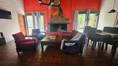 a living room with red walls and a fireplace at Balcón de las sierras in Villa Carlos Paz