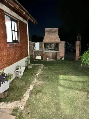 a backyard at night with a brick house at Cabaña petiza in Mina Clavero