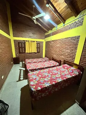 a bedroom with two beds in a brick wall at Cabaña petiza in Mina Clavero