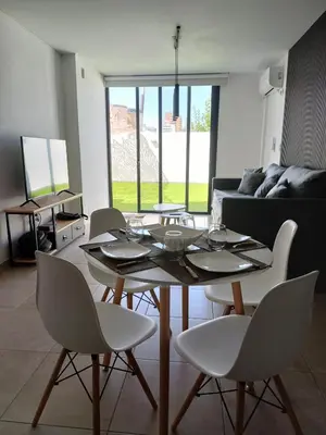 a living room with a table and chairs and a couch at dto 22 TEMPO in Villa Carlos Paz