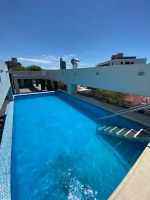 a swimming pool on the roof of a building with the ocean at dto 22 TEMPO in Villa Carlos Paz