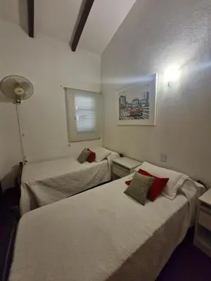 a hotel room with two beds and a lamp at Hermosa Casa en Villa del Lago Carlos Paz Vista al lago, zona exclusiva y residencial in Cordoba