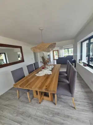a dining room with a wooden table and chairs at Hermosa Casa en Villa del Lago Carlos Paz Vista al lago, zona exclusiva y residencial in Cordoba