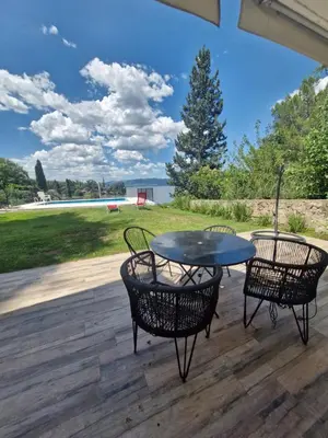 a patio with two chairs and a table on a deck at Hermosa Casa en Villa del Lago Carlos Paz Vista al lago, zona exclusiva y residencial in Cordoba