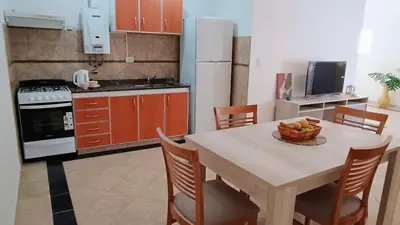 a kitchen with a table with a bowl of fruit on it at Departamentos Elisabeth in Tanti