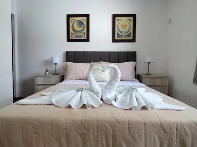 two swans are forming a heart on a bed at Departamentos Elisabeth in Tanti