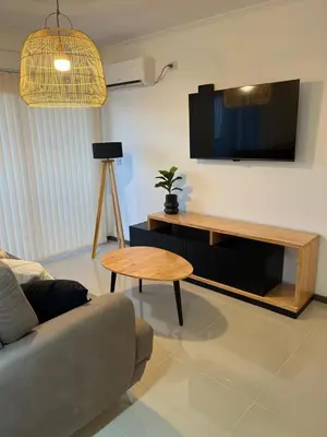a living room with a couch and a table and a tv at Departamento centrico en carlos paz in Villa Carlos Paz