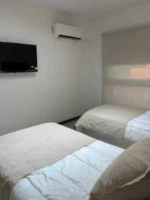two beds in a room with a tv on the wall at Departamento centrico en carlos paz in Villa Carlos Paz